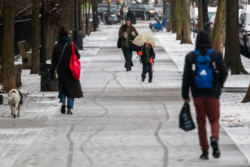 People walk through light morning snow in Brooklyn on Feb. 6, 2025 in New York City.