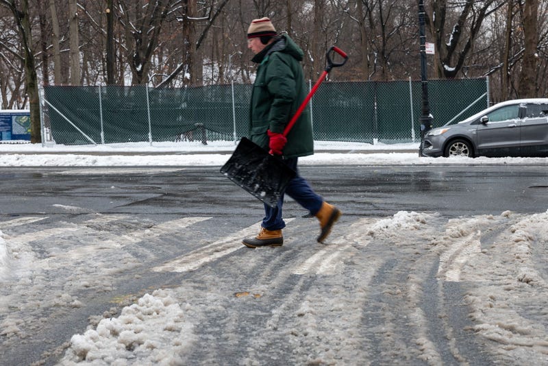 A person walks with a shovel after an overnight snowstorm on Feb. 9, 2025 in Brooklyn. 