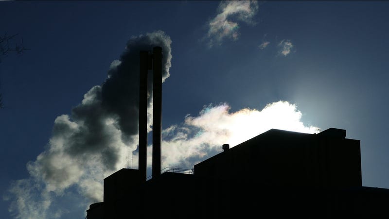 Thick exhaust cloud over high industrial chimney
