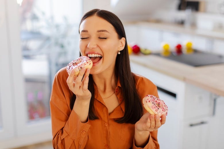 Woman eating doughnuts in her kitchen