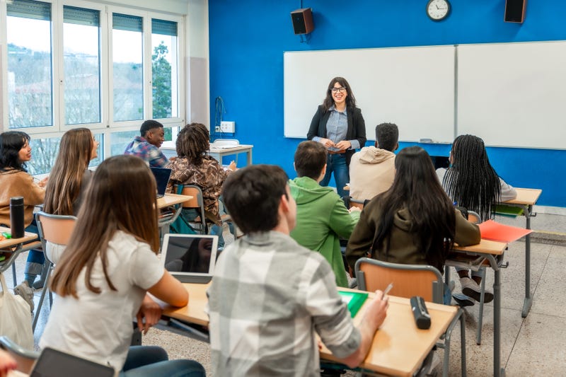 A teacher stands in front of a high school class.