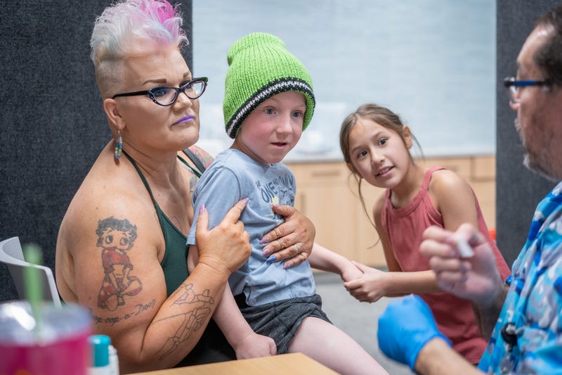 LUBBOCK, TEXAS - MARCH 01: Ambra Hawksley holds her son Andrik Hawksley, age 6, while his sister JaeLynn holds his hand as he prepares to get an MMR vaccine from Raynard Covarrubio, at a vaccine clinic put on by Lubbock Public Health Department on March 1, 2025 in Lubbock, Texas. Cases of Measles are on the rise in West Texas as over 150 confirmed case have been seen with one confirmed death.(Photo by Jan Sonnenmair/Getty Images)