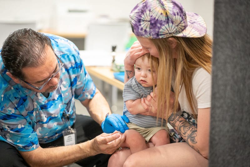 One year-old River Jacobs is held by his mother, Caitlin Fuller, while he receives an MMR vaccine from Raynard Covarrubio, at a vaccine clinic put on by Lubbock Public Health Department on March 1, 2025 in Lubbock, Texas. 