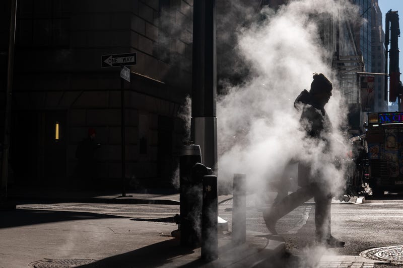 People walk along Wall Street on a cold morning