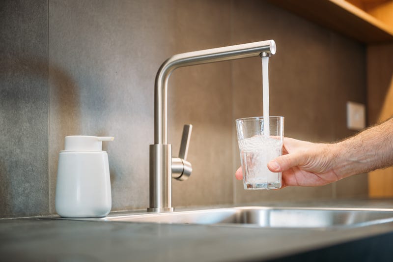Water from a faucet going into a drinking glass