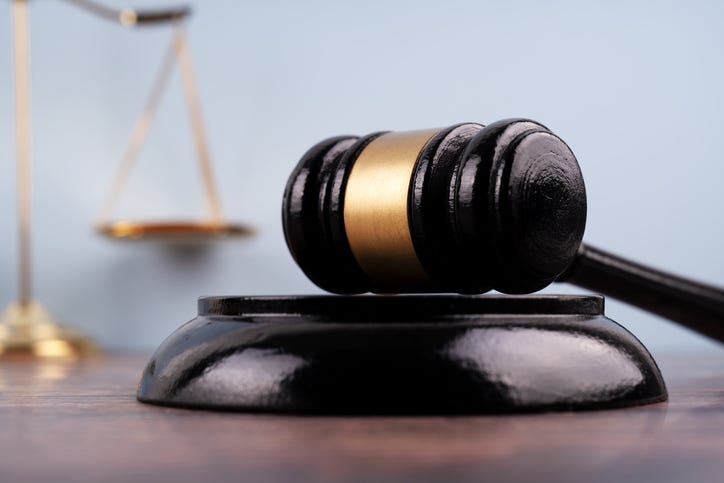 Close up of a gavel set with background of blurred image scales of justice.