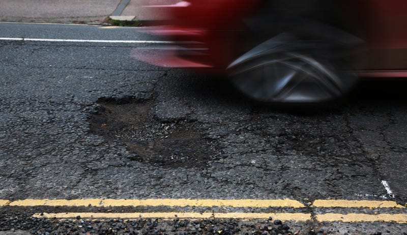 A car driving over a pothole.