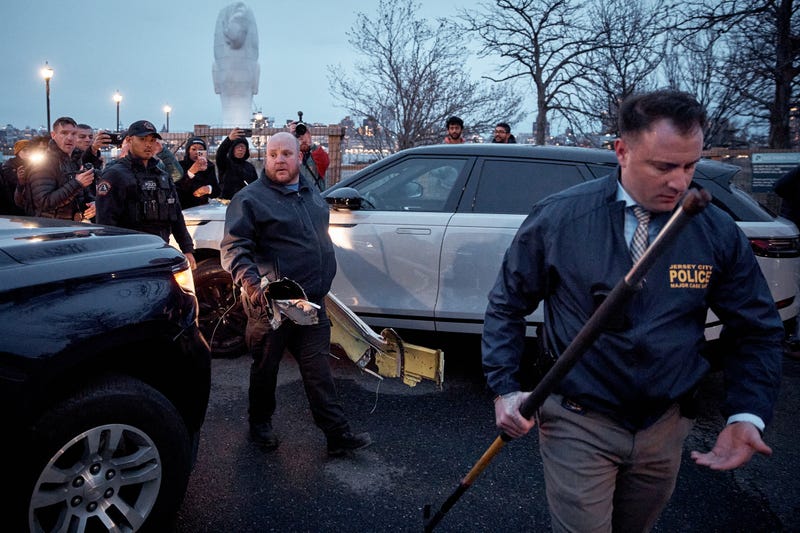 Police officers carry parts of a crashed helicopter on April 10, 2025 in Jersey City