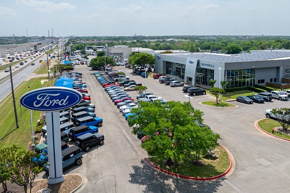 In an aerial view, vehicles are seen for sale on a lot at a dealership on April 18, 2025 in Austin, Texas.