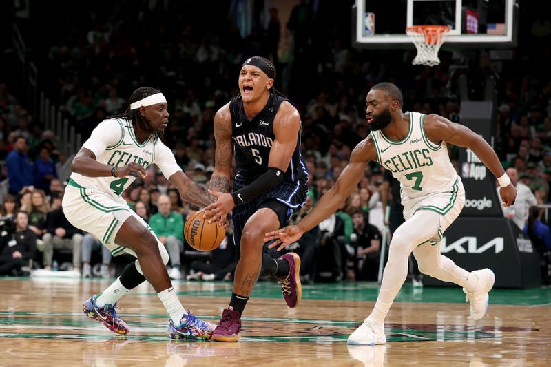 Paolo Banchero #5 of the Orlando Magic battles for possession against Jrue Holiday #4 and Jaylen Brown #7 of the Boston Celtics in Game One of the Eastern Conference First Round NBA Playoffs at TD Garden on April 20, 2025 in Boston, Massachusetts.