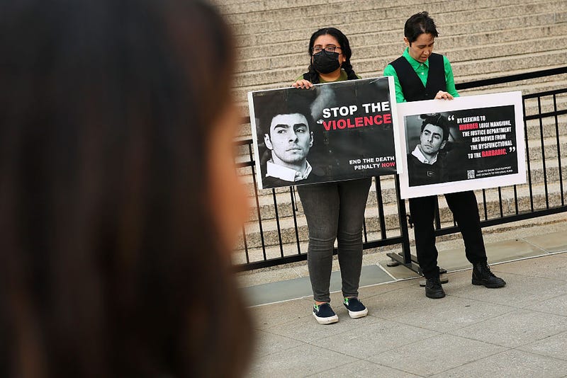 People hold signs in front of Federal Court ahead of an arraignment hearing for Luigi Mangione, accused gunman in the killing of UnitedHealthcare CEO Brian Thompson, on April 25, 2025 in New York City. 