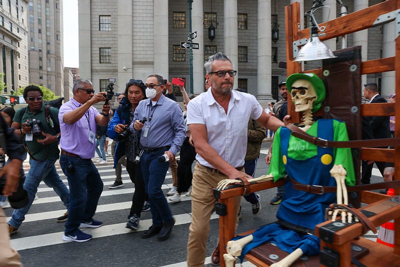 Lobaido next to his 'Fry Him!' statue outside a federal court in Manhattan on April 25, 2025.