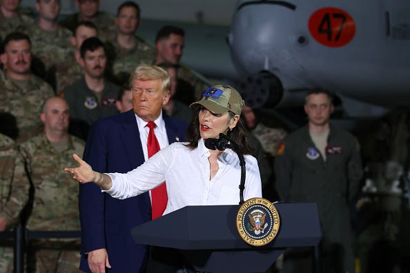 President Donald Trump listens as Michigan Gov. Gretchen Whitmer speaks at Selfridge Air National Guard Base.