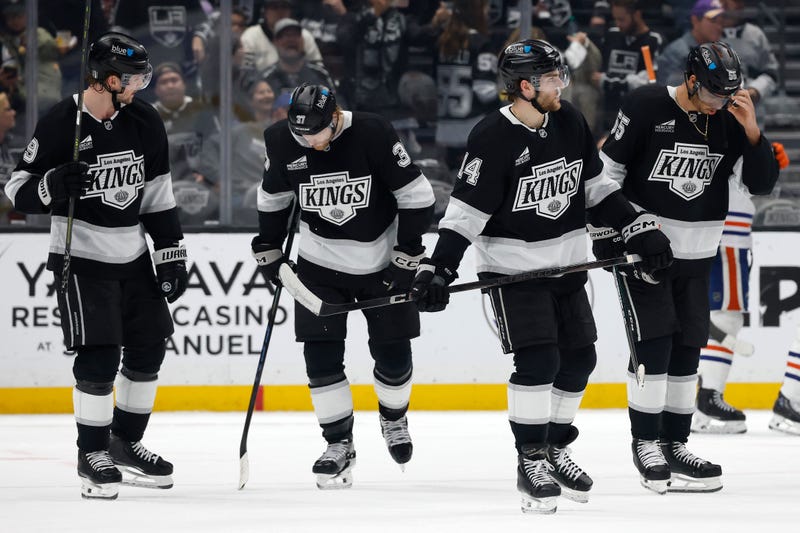 four la kings hockey players stand on ice
