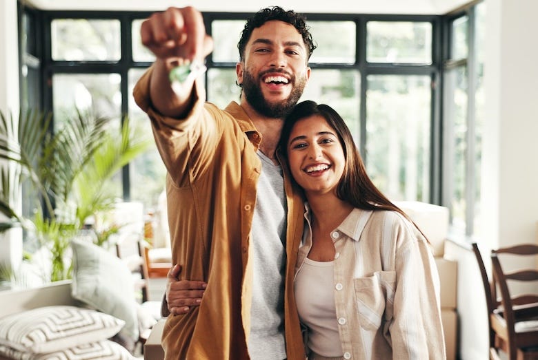 Young couple holding keys moving into their new home