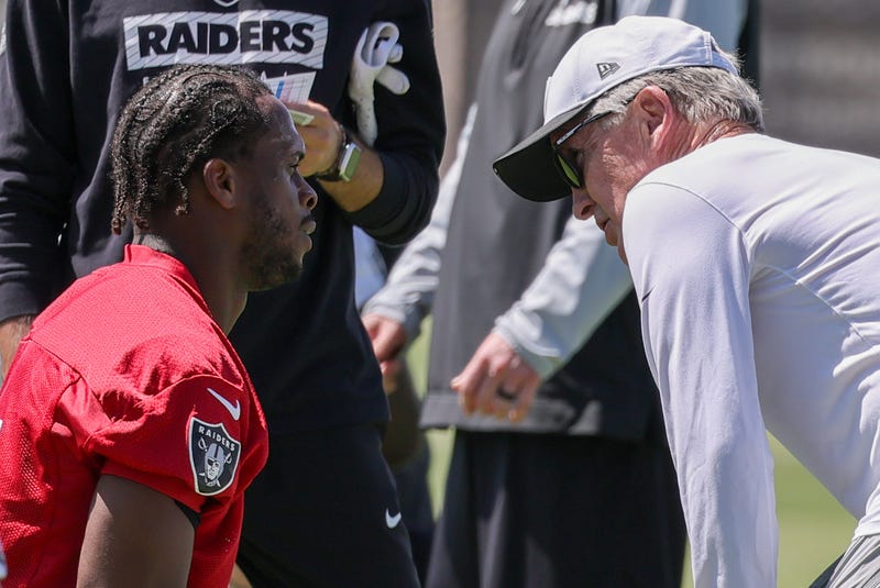 Geno Smith #7 of the Las Vegas Raiders stretches as he talks with head coach Pete Carroll during an OTA offseason workout at the Las Vegas Raiders Headquarters/Intermountain Healthcare Performance Center on May 21, 2025 in Henderson, Nevada.