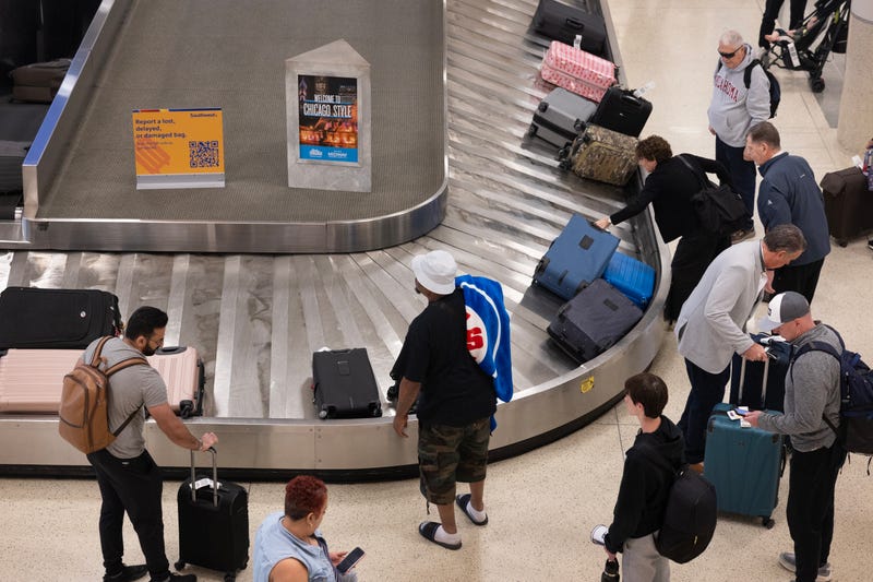 CHICAGO, ILLINOIS - MAY 27: Passengers retrieve luggage from a baggage carousel after arriving at Midway Airport on a Southwest Airlines flight on May 27, 2025 in Chicago, Illinois. Beginning tomorrow, Southwest Airlines will begin to charge most passengers $35 for their first checked bag and $45 for their second, ending its longstanding free checked bag policy. (Photo by Scott Olson/Getty Images)