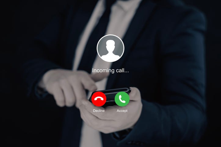 Notification of an incoming call on a smartphone in the hand of a businessman in a dark suit
