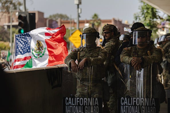 A United States of America and Mexico hybrid flag is flown next to National Guard standing guard outside of the Edward Roybal Federal Building as protesters gather on June 9, 2025 in Downtown Los Angeles, California. 