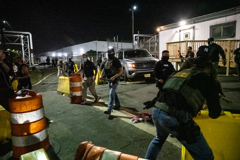 Police officers clear a path for a car leaving from Delaney Hall, a migrant detention facility, after anti-U.S. Immigration and Customs Enforcement (ICE) activists tried to block it on June 12, 2025
