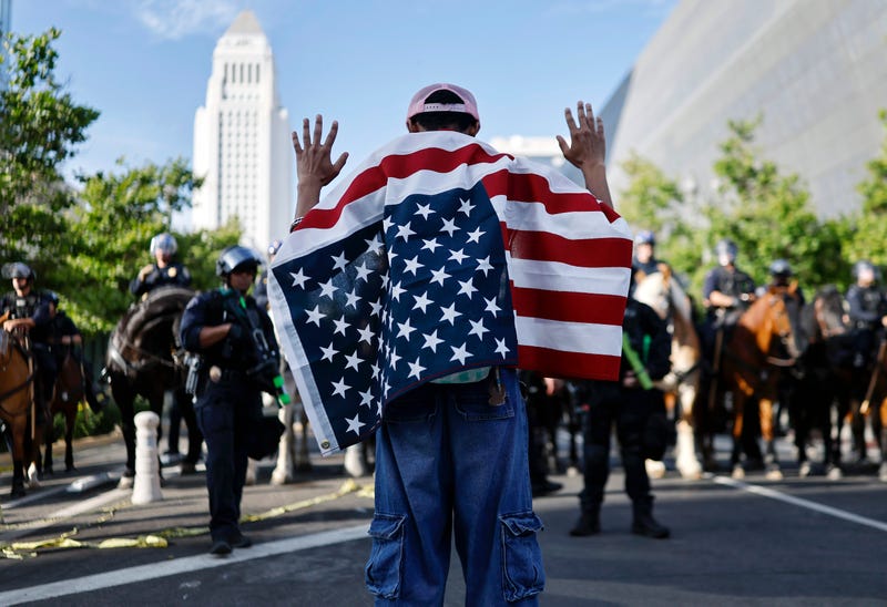 man wearing american flag with hands up