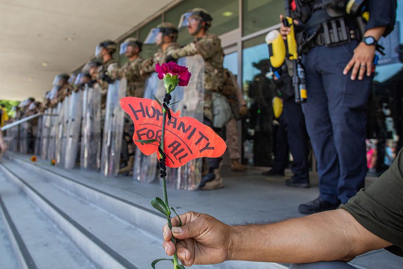 A demonstrator outside the federal building in Los Angeles as National Guard forces guard the facility.