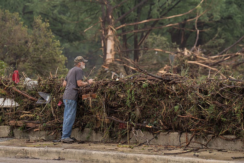 A resident surveys flood damage and debris along the Guadalupe River on July 5, 2025 in Kerrville, Texas.
