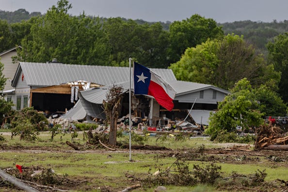 A Texas state flag flies in a yard filled with debris on July 6, 2025 in Hunt, Texas. Heavy rainfall caused flooding along the Guadalupe River in central Texas with multiple fatalities reported.