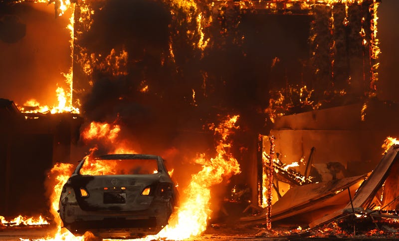  A car and home burn during the Eaton Fire on January 8, 2025 in Altadena, California. 