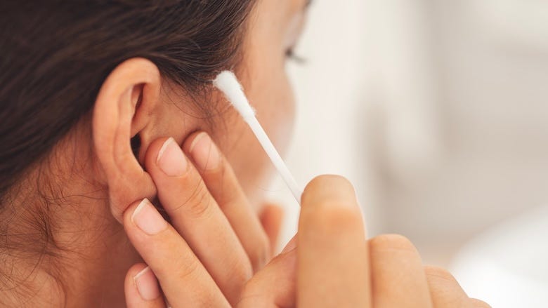Woman using a Q-tip to clean her ear