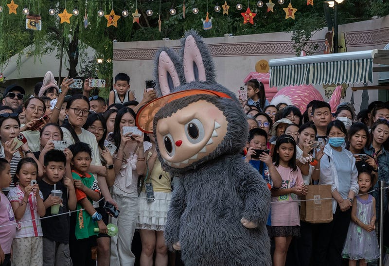 BEIJING, CHINA - JULY 17: A performer wears a costume of a character from Pop Mart's hugely popular Labubu dolls series while dancing for visitors at the Pop Land theme park on July 17, 2025 in Beijing, China. The viral 'monster' dolls are so popular that Pop Mart, the Beijing-based company behind the craze, saw its profits soar by 350% in the first half of the year. The obsession with Labubu, furry creatures with pointy ears and exactly nine teeth, have inspired long lineups and occasional tussles in some countries as well as a growing black market for imposter products seeking to cash in. Labubu dolls, created by Hong Kong artist Kasing Lung, first debuted in 2019 but hit global status more recently when they became the accessory toy of choice for celebrities including Rihanna, Dua Lipa, and Blackpink's Lisa. A key part of Pop Mart's commercial success with Labubu is so-called 'blind boxes' where customers find out what they buy only when they open the package. (Photo by Kevin Frayer/Getty Images)