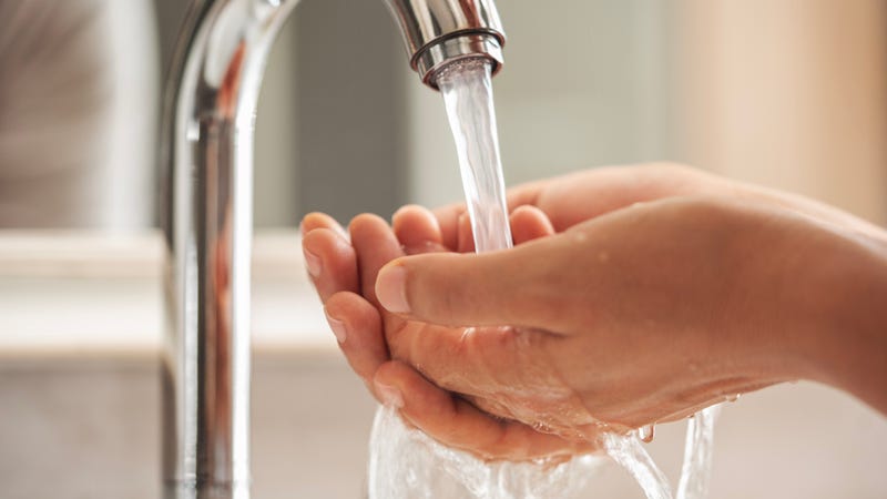 Woman washing her hands in the bathroom - stock photo