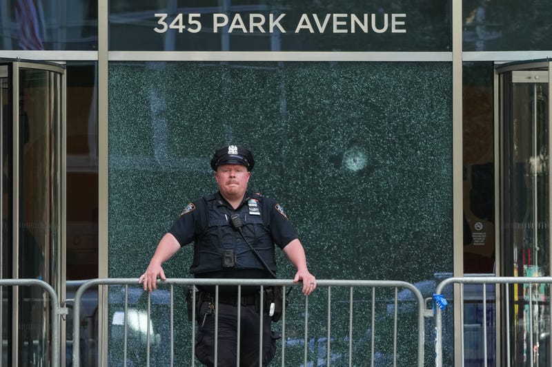An NYPD officer stands outside the 345 Park Avenue building, the scene of last night's deadly shootings in Midtown Manhattan in New York on July 29, 2025