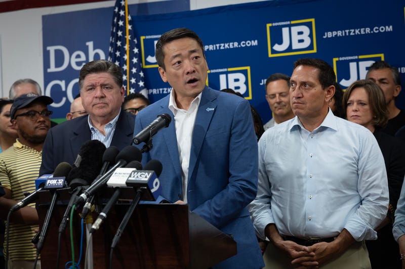 CAROL STREAM, ILLINOIS - AUGUST 03: Illinois Governor JB Pritzker (L) and Texas Rep. Trey Martinez Fischer (R) listen as Texas House Democratic Caucus Chair Gene Wu speaks to reporters during a press conference at the DuPage County Democratic Party headquarters on August 03, 2025 in Carol Stream, Illinois. Wu was with a group of Democratic Texas lawmakers who left the state earlier today so a quorum could not be reached during a special session called to redistrict the state. (Photo by Scott Olson/Getty Images)