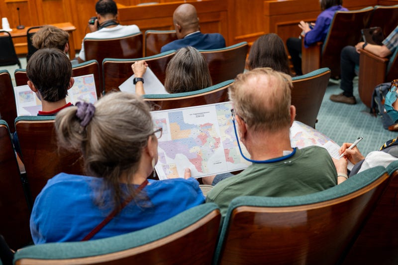 AUSTIN, TEXAS - AUGUST 07: Attendees view a map during a Senate Special Committee on Congressional Redistricting public testimony hearing on August 07, 2025 in Austin, Texas. The Senate Special Committee on Congressional Redistricting met to hear public testimony on Congressional plan C2308. Earlier this week, Texas Democratic lawmakers fled the state in an attempt to protest and deny quorum for votes on the proposed Republican redistricting plan, which would secure five additional GOP seats in the U.S. House. Gov. Greg Abbott has threatened to remove lawmakers who do not return and has asked the Texas Supreme Court to expel House Democratic leaders who fled the state. (Photo by Brandon Bell/Getty Images)
