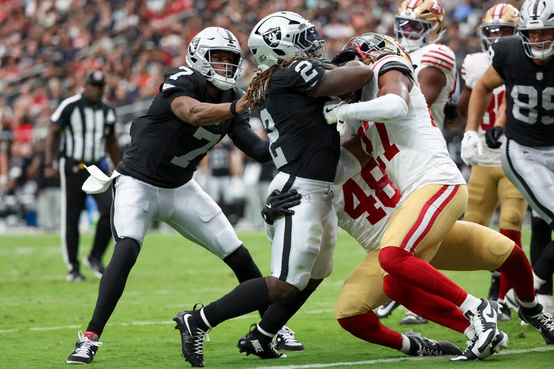 Geno Smith #7 of the Las Vegas Raiders pushes Ashton Jeanty #2 past Tatum Bethune #48 and Ji'Ayir Brown #27 of the San Francisco 49ers while Jeanty scores a rushing touchdown during the second quarter of the NFL Preseason 2025 game at Allegiant Stadium on August 16, 2025 in Las Vegas, Nevada.