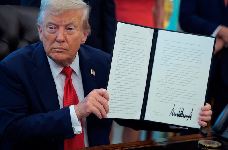 President Donald Trump signs executive orders in the Oval Office at the White House on Aug. 25, 2025.