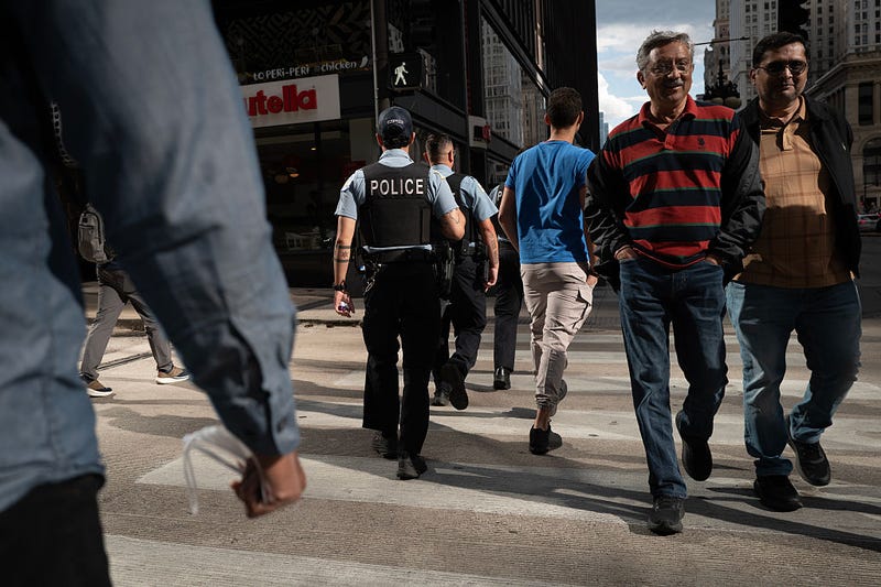 A Chicago police officer crosses Lake Street with pedestrians at Michigan Avenue. 