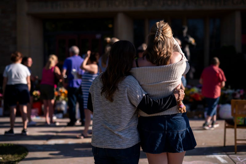 People embrace outside Annunciation Church and School on August 30, 2025 in Minneapolis, Minnesota. 