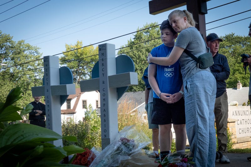 People visit a memorial to yesterday's shooting victims in front of Annunciation Catholic Church on August 28, 2025 in Minneapolis, Minnesota.