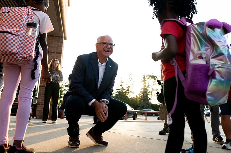Minnesota Gov. Tim Walz (C) greets students as they arrive for the first day of school at Deerwood Elementary on September 2, 2025 in Eagan, Minnesota. 