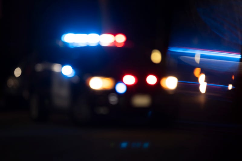 Abstracted view of police lights on a city street at night with lens flare.
