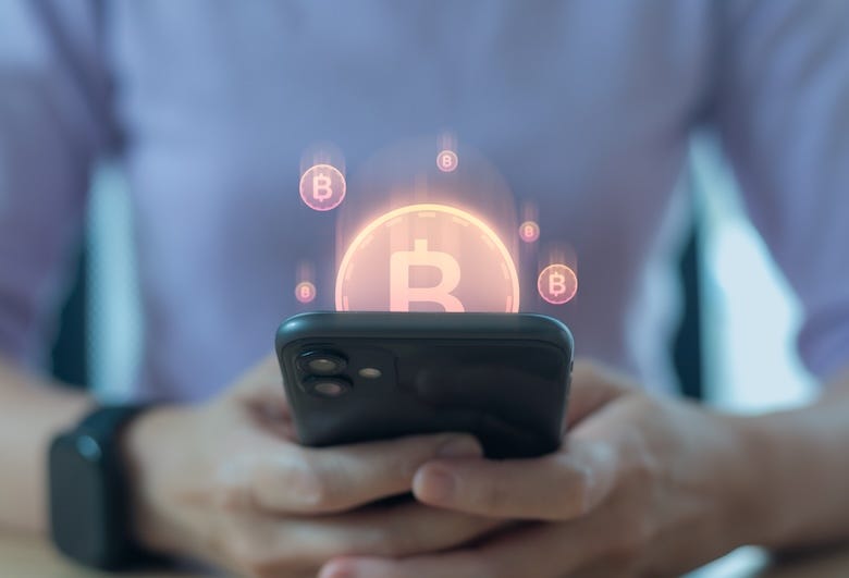 Man holding smartphone with Bitcoin hologram