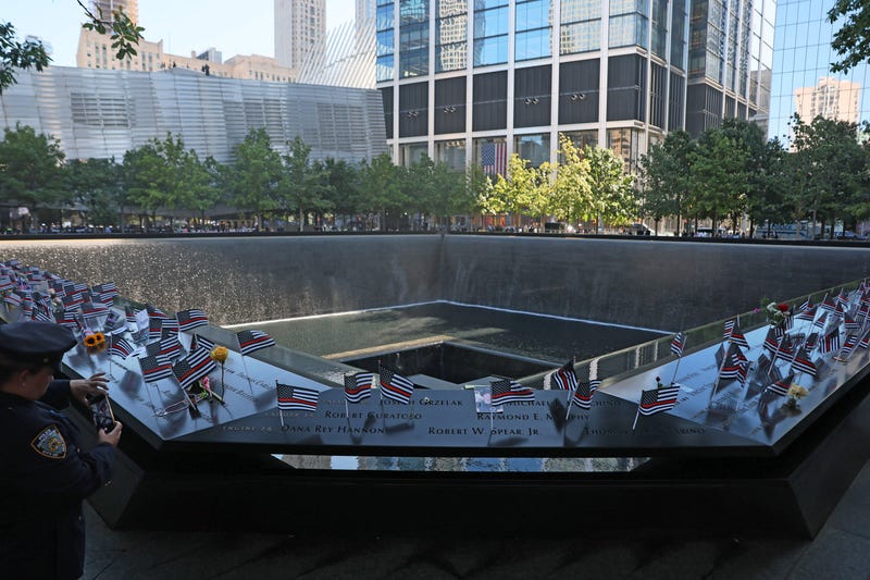 A police officer takes a photo at the South Tower reflecting pool during the annual 9/11 Commemoration Ceremony at the National 9/11 Memorial and Museum on September 11, 2025 in New York City.