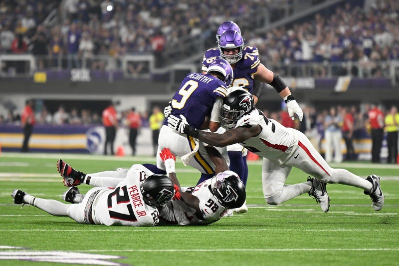 J.J. McCarthy #9 of the Minnesota Vikings is tackled by Zach Harrison #96, Ruke Orhorhoro #98, and James Pearce Jr. #27 of the Atlanta Falcons during the second quarter in the game at U.S. Bank Stadium on September 14, 2025 in Minneapolis, Minnesota.