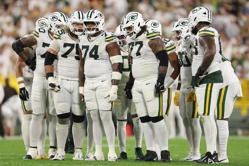 Darian Kinnard #70, Sean Rhyan #75, Elgton Jenkins #74 and Jordan Morgan #77 of the Green Bay Packers huddle against the Washington Commanders at Lambeau Field on September 11, 2025 in Green Bay, Wisconsin.