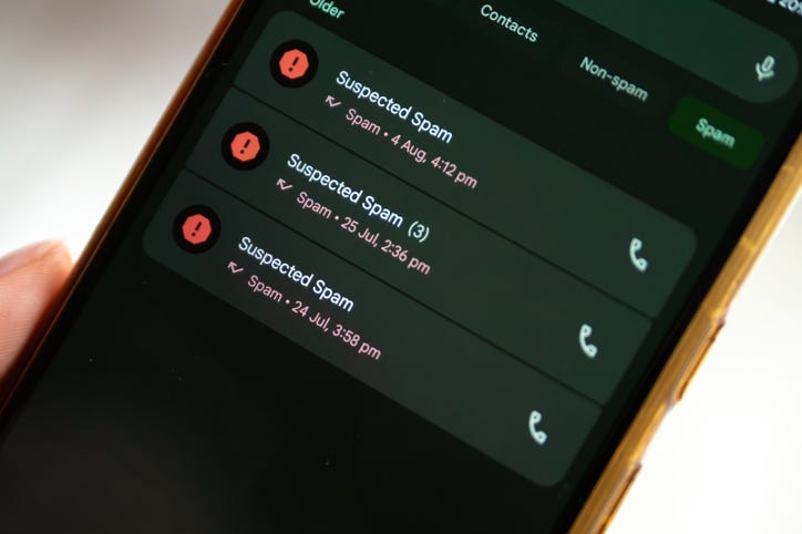 A mobile phone screen displays a list of past calls, all labeled as "Suspected Spam." The repetition of the warning icon and text shows the persistent nature of spam calls and the need for protective measures.