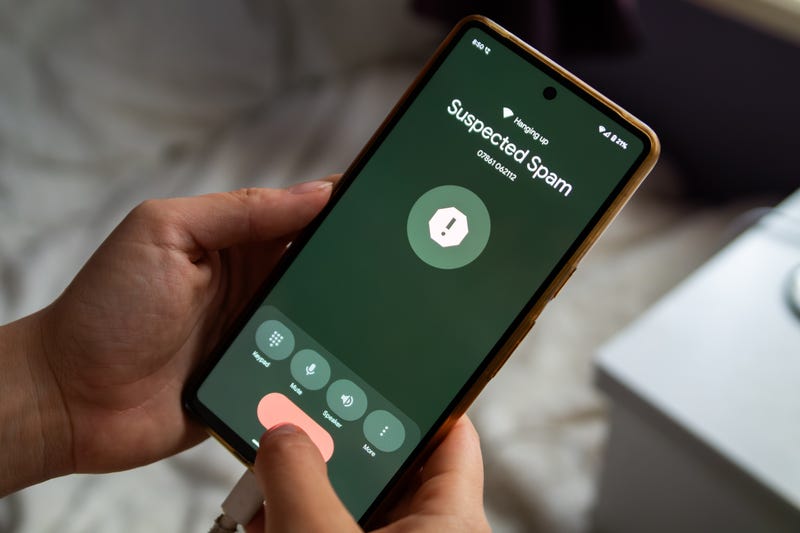 A cell phone displays a call from a "suspected spam" number.