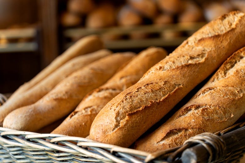 Fresh baguettes lying in wicker basket at bakery