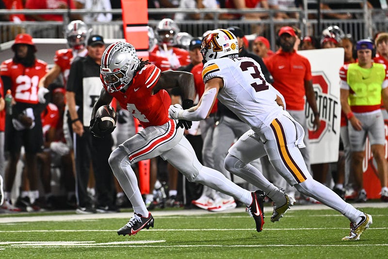 Jeremiah Smith #4 of the Ohio State Buckeyes runs with the ball as Koi Perich #3 of the Minnesota Golden Gophers defends during the first quarter of a game at Ohio Stadium on October 4, 2025 in Columbus, Ohio. 